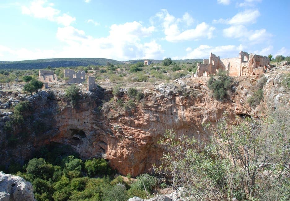 The massive sinkhole chasm at Kanlıdivane surrounded by ruins